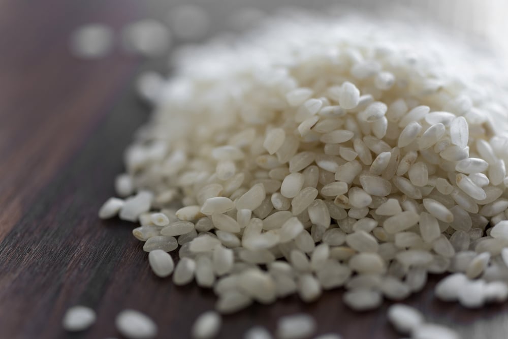 Paella rice in a pile on a wooden surface